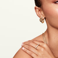 Model wearing gold ridge ring with matching jewelry 