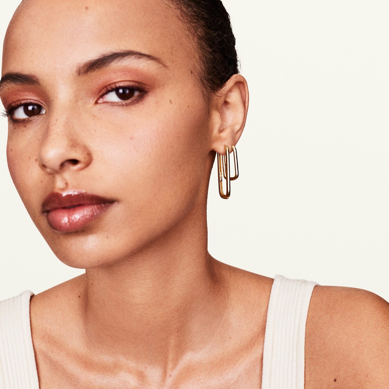 Model wearing gold long earrings