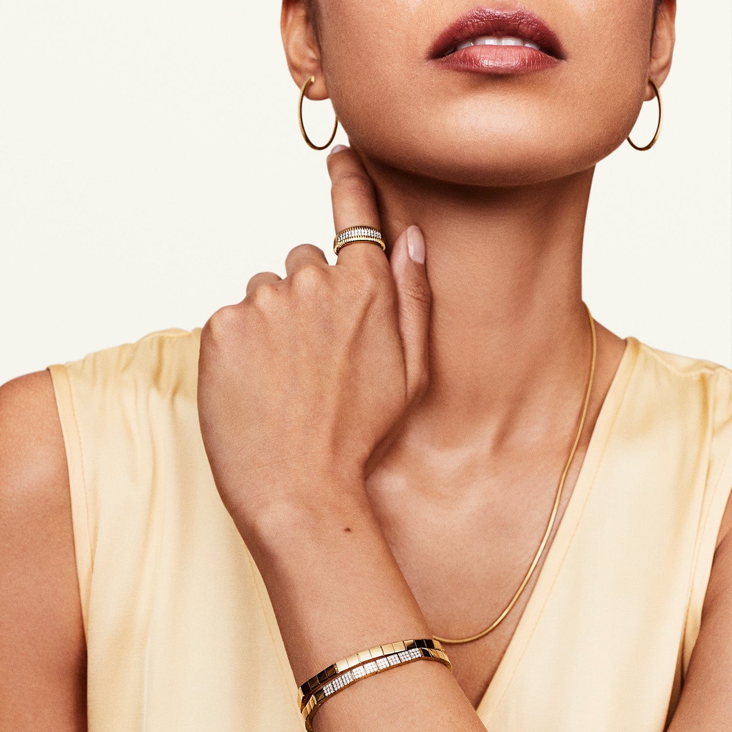 Model wearing gold diamond square bracelet with other accessories