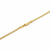 A close-up of a yellow gold snake chain necklace clasp on a white surface.