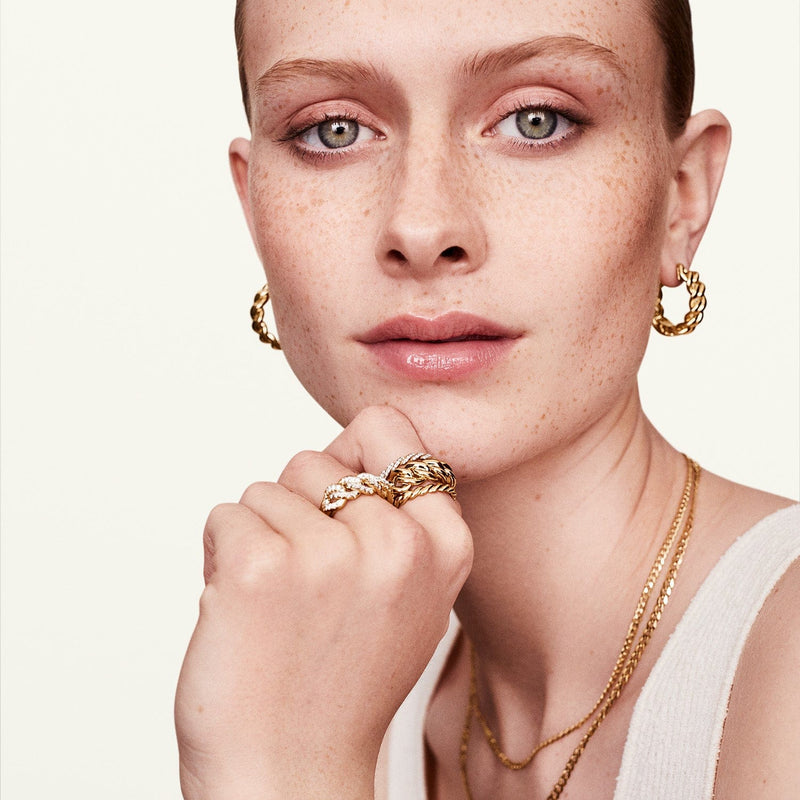 A woman showcasing the 14k yellow gold pave infinity ring along with other jewelry.