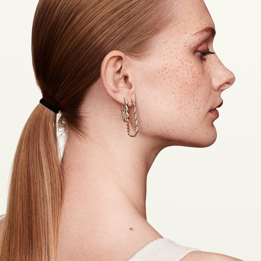 Model showing side profile wearing infinity diamond earrings