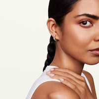 Model showcasing allumare white gold diamond huggie hoop earring