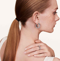 Model showcasing chain hoop earrings and matching ring