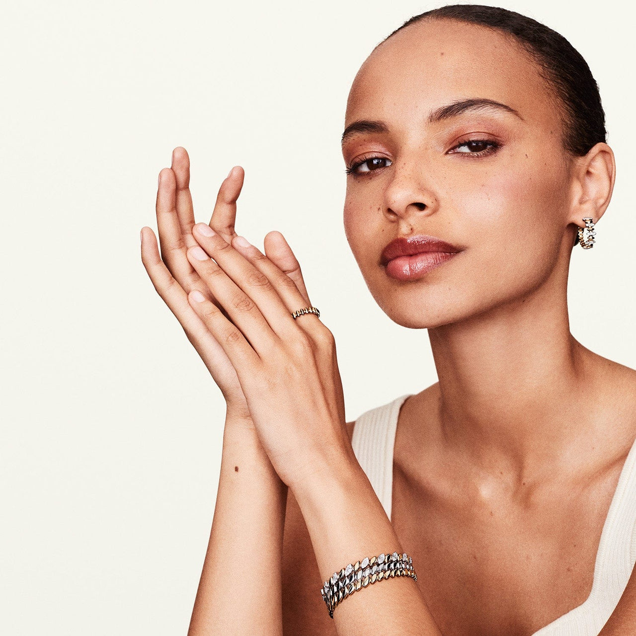 Model wearing several jewelry pieces including leaf bracelet
