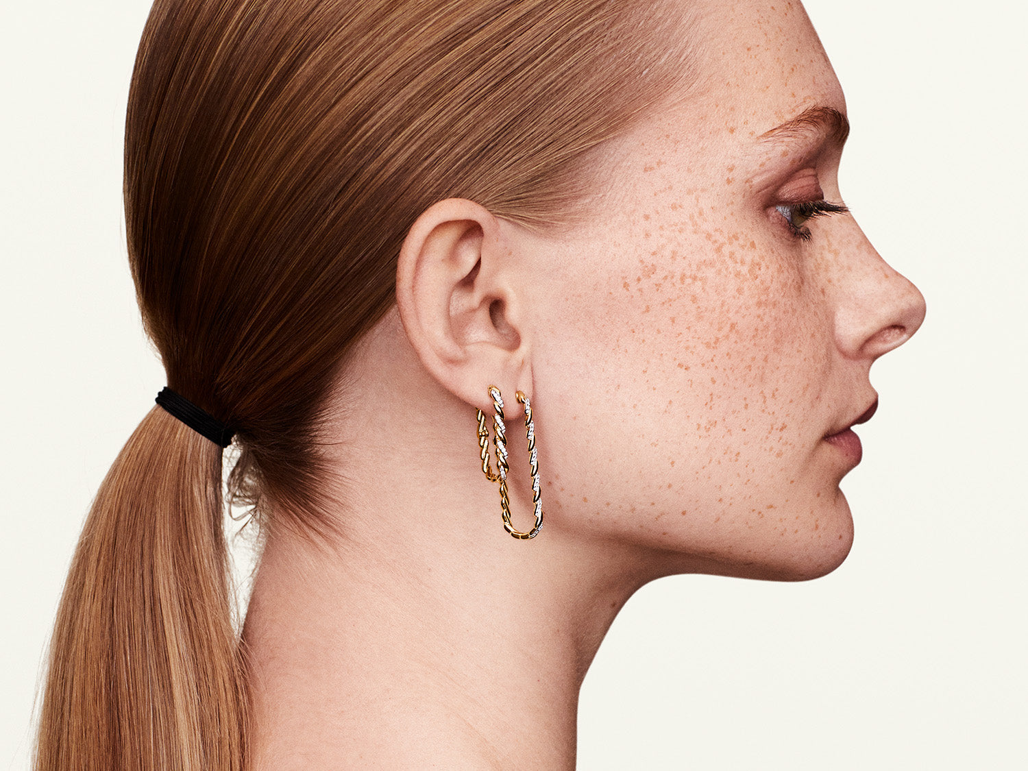 Model wearing white gold long hoop earrings