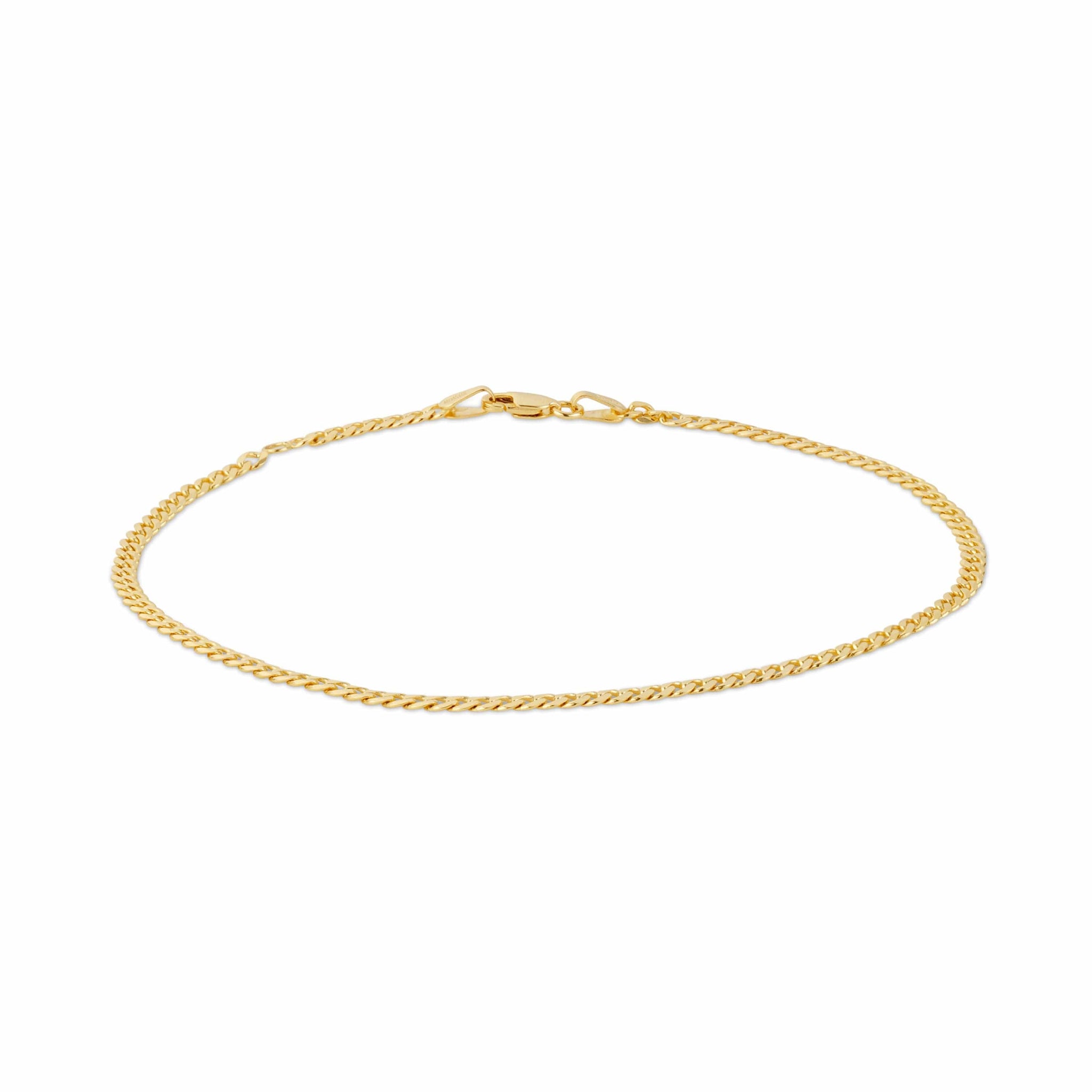 A gold curb link chain bracelet on a white backdrop.